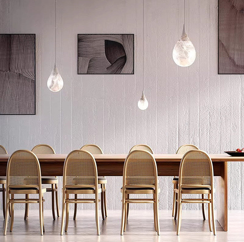 Multiple Tova alabaster teardrop pendant lights above wooden dining chairs dining room
