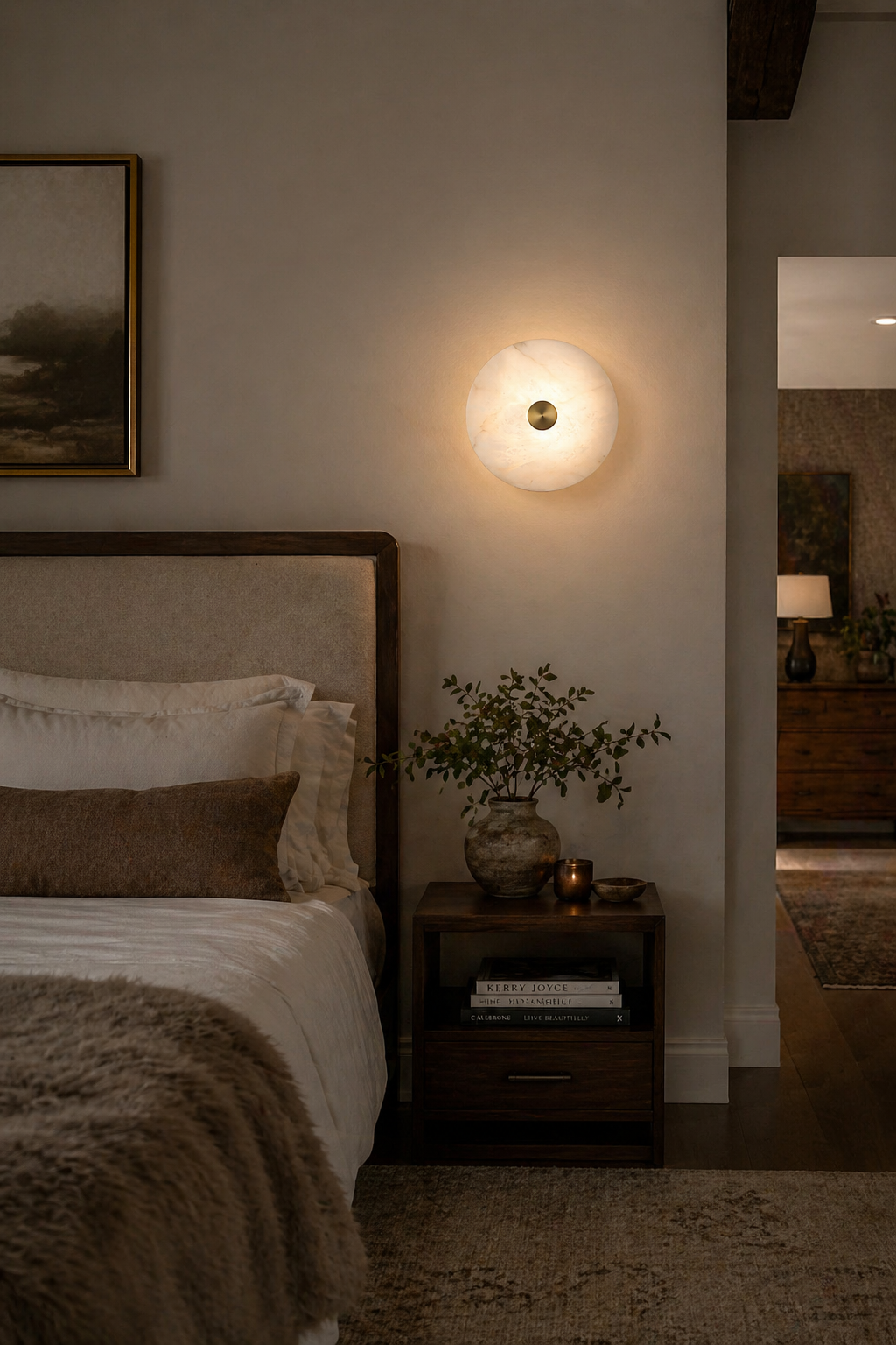 Lit disc alabaster wall light closeup pale neutral plaster wall minimalist shot