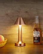 Illuminated Rose Gold Cordless Touch Table Lamp on Wooden Surface with Drink Bottle