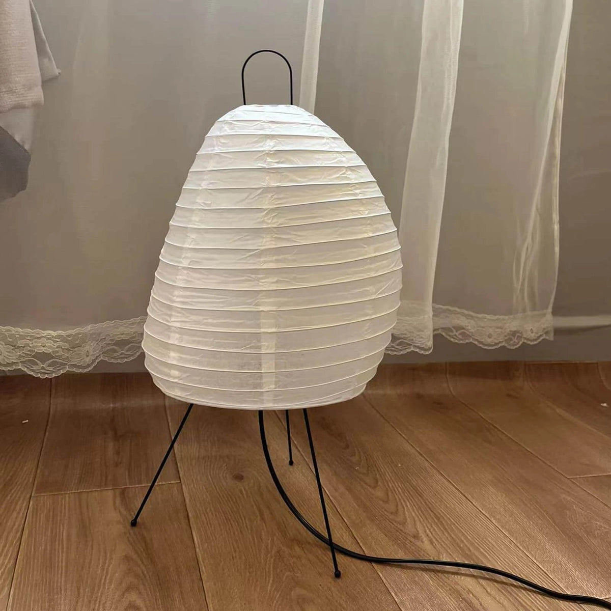 Illuminated Modern Tripod Table Lamp on Wooden Floor Setting