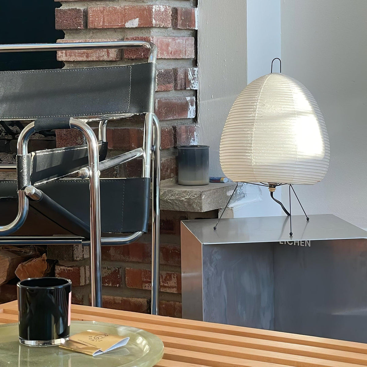 Akari Paper 1A Table Lamp placed on side table beside metal modern chair
