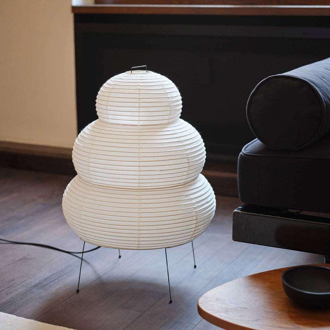 Akari Paper 25N Table Lamp soft ambient lighting next to dark sofa furniture