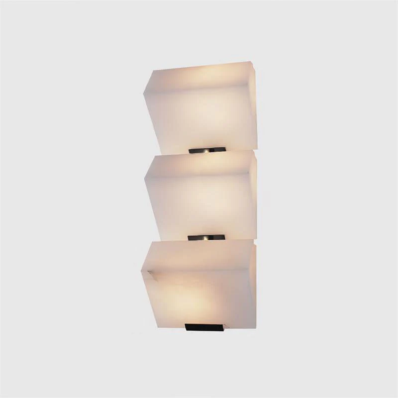 Lit three tier alabaster tiered wall sconce minimalist isolated white studio backdrop