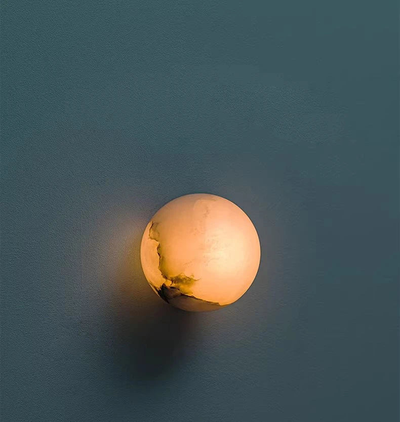 Illuminated Modern Natural Marble Globe Wall Sconce on Dark Background