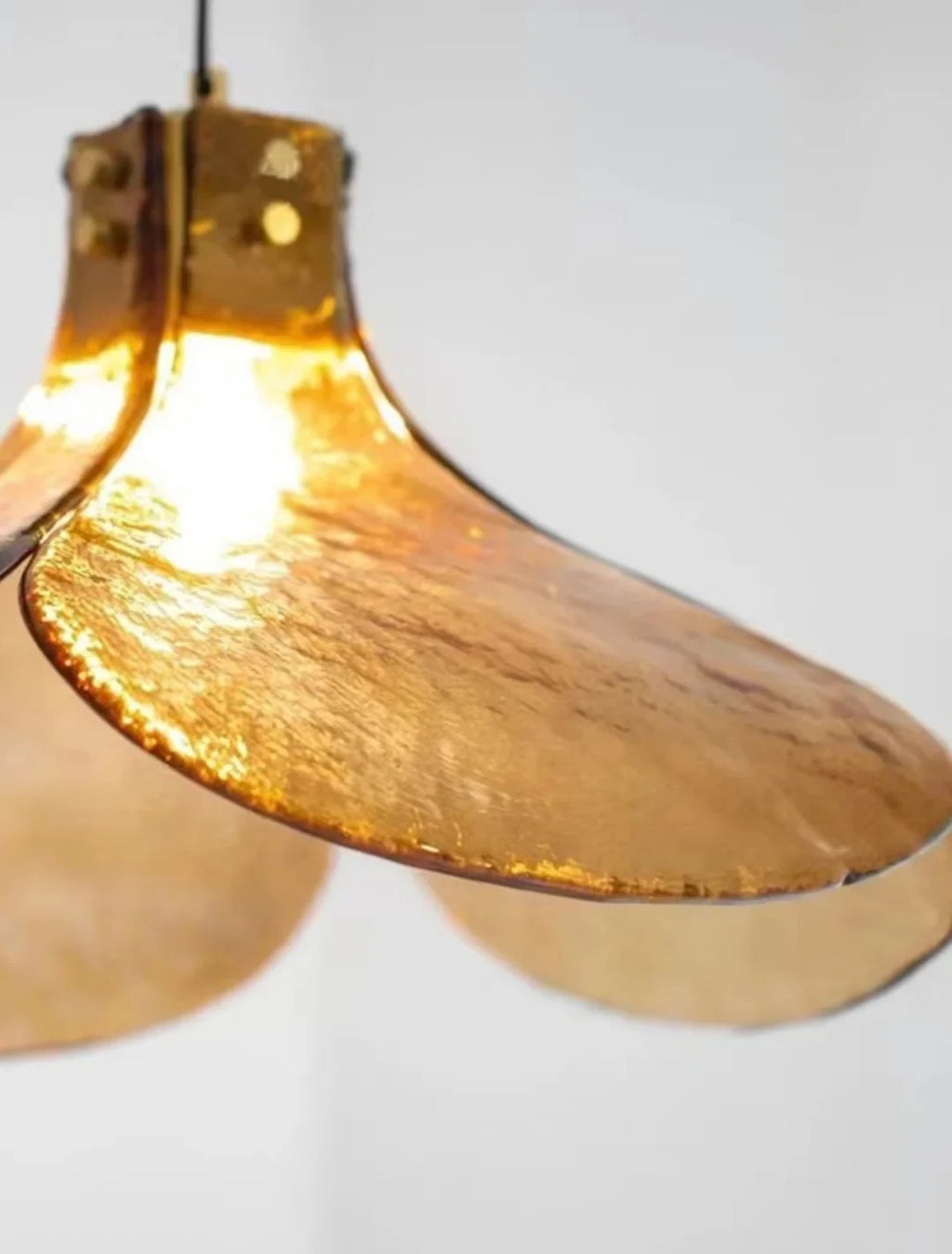 Close Up View of Illuminated Amber Petal Art Glass and Brass Connection Details