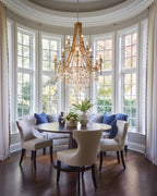 Crystal Chandelier Over Round Dining Table in Bay Window Nook
