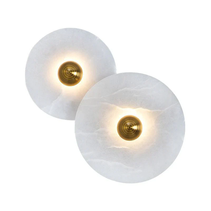 Two overlapping glowing Solaris Stone Disc Wall Lamps with brass hardware