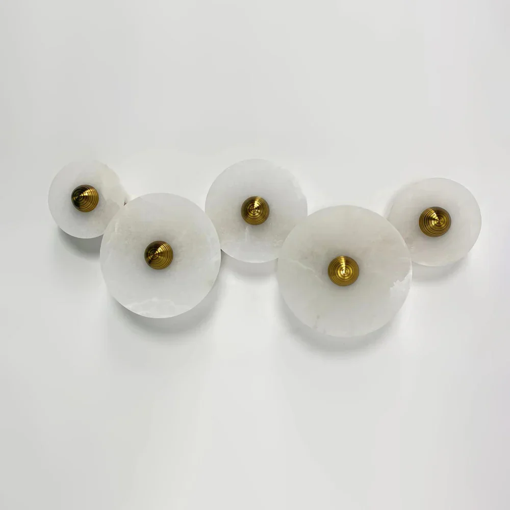Five-piece cluster of Solaris alabaster disc wall sconces on neutral wall