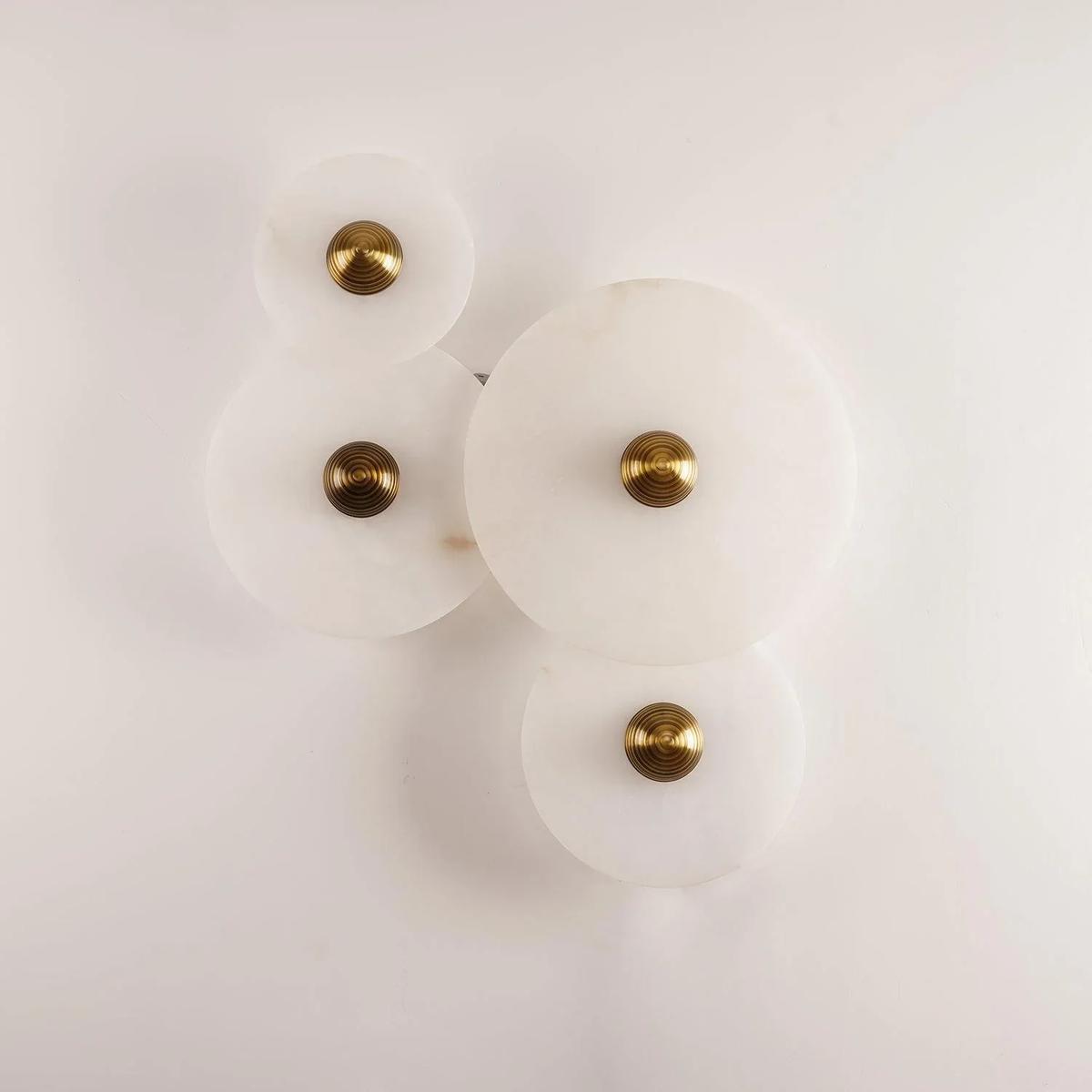 Four-piece Solaris stone disc wall lamp combination on plain white wall
