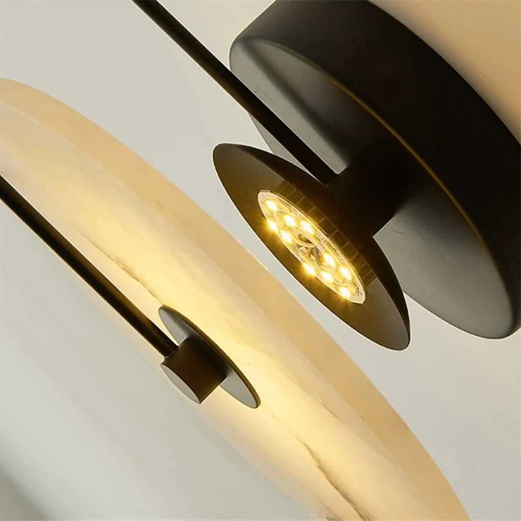 Front View of Illuminated Modern Round Alabaster Wall Sconce with Black Stem