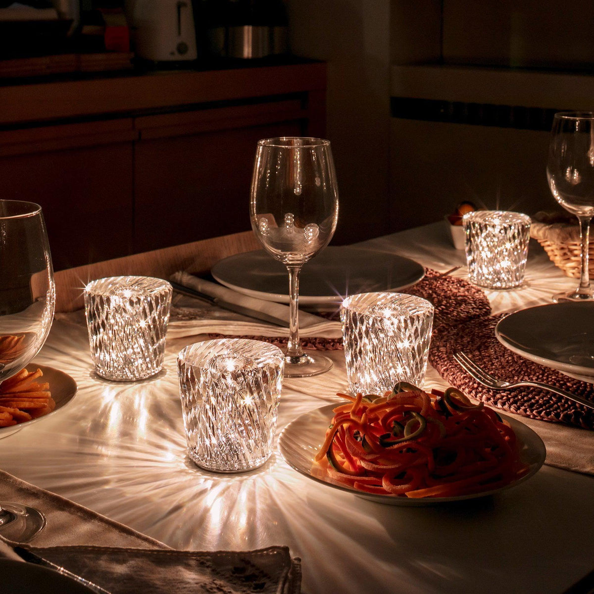 Multiple glowing Becrux crystal table lamps decorating formal dining table with tableware