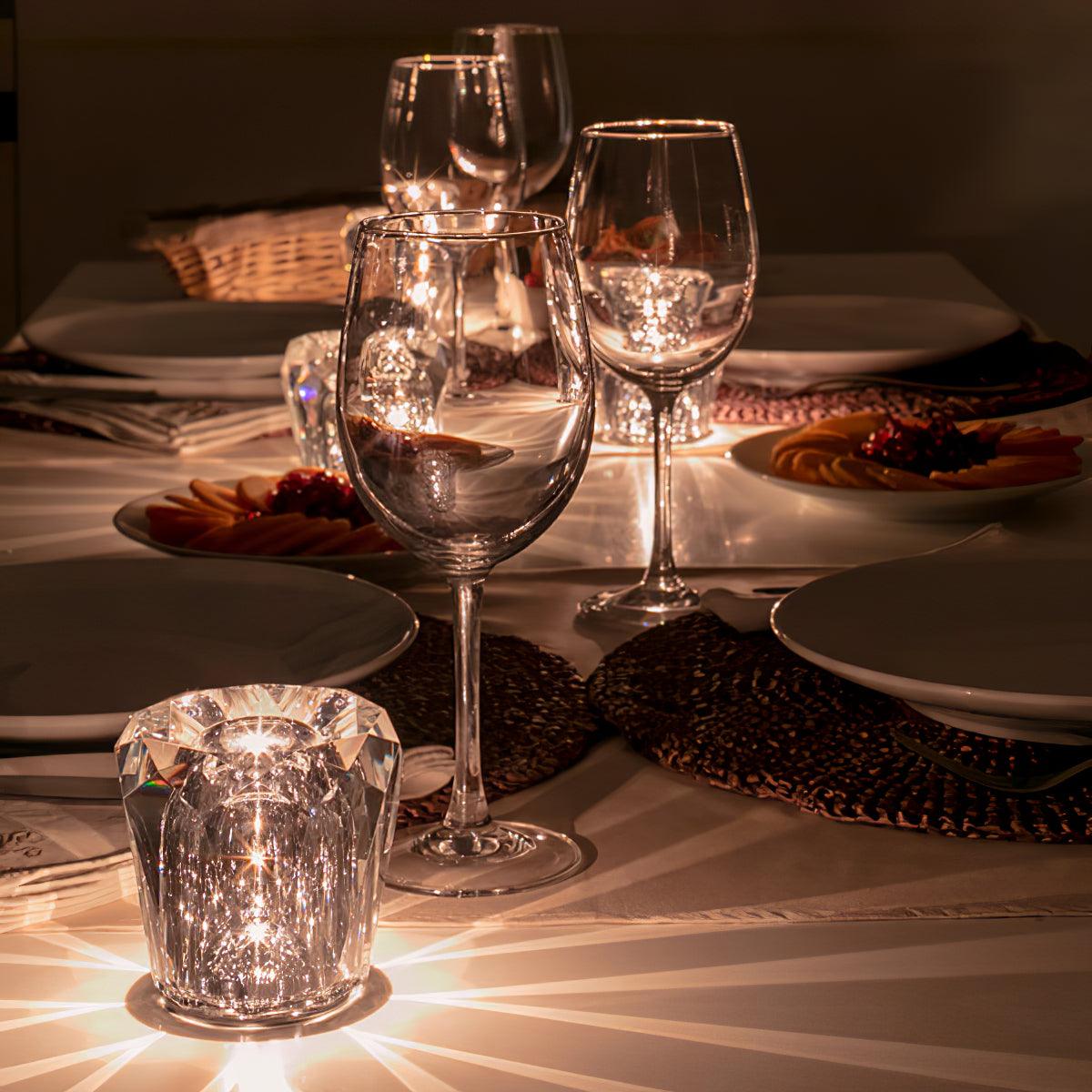 Lit Becrux crystal cordless lamp arranged alongside wine glasses elegant dinner table setting