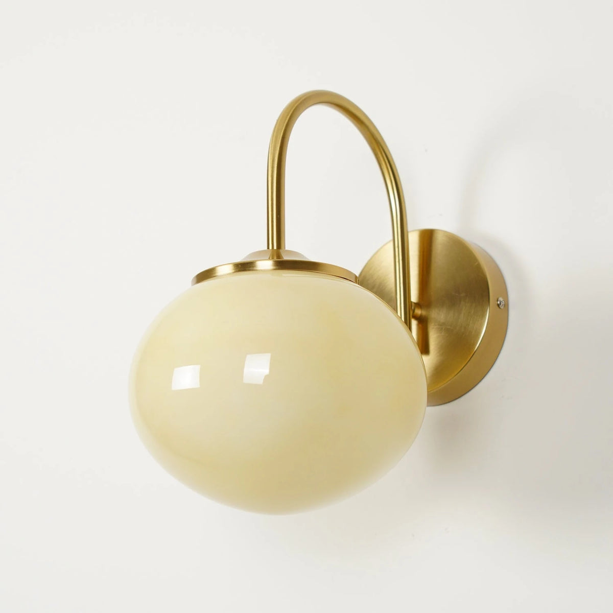 Brass Gooseneck Cream Globe Wall Sconce Studio Product Shot