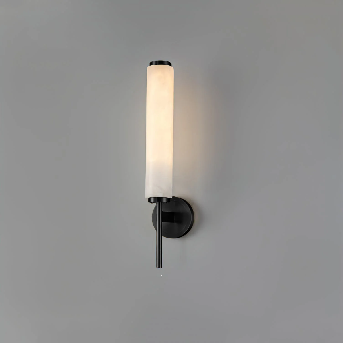 Brindisi alabaster wall lamp matte black metal base glowing cylindrical stone shade grey wall