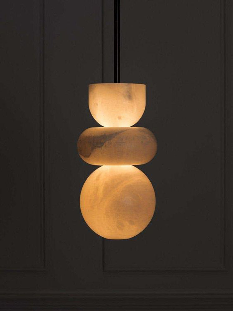 Lit stacked alabaster pendant lamp dark background warm ambient lighting scene
