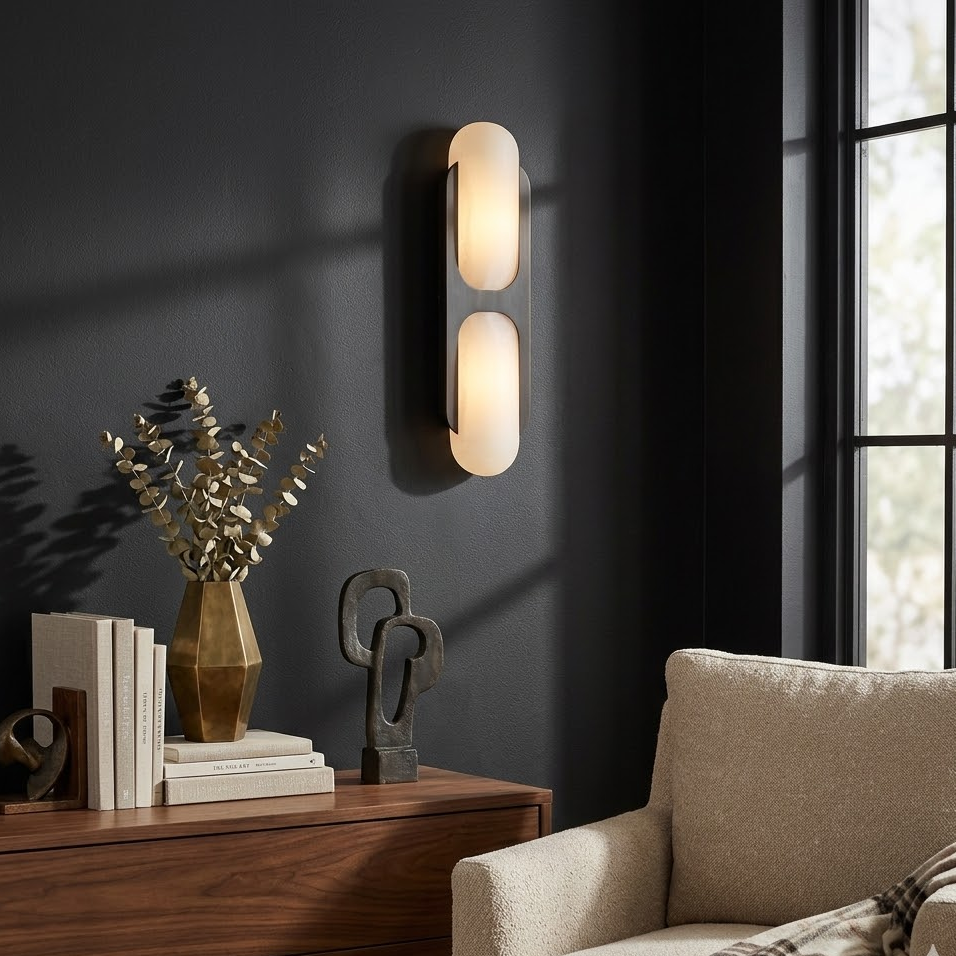Lit Capsule alabaster wall light mounted on dark interior wall beside wooden cabinet living room decor