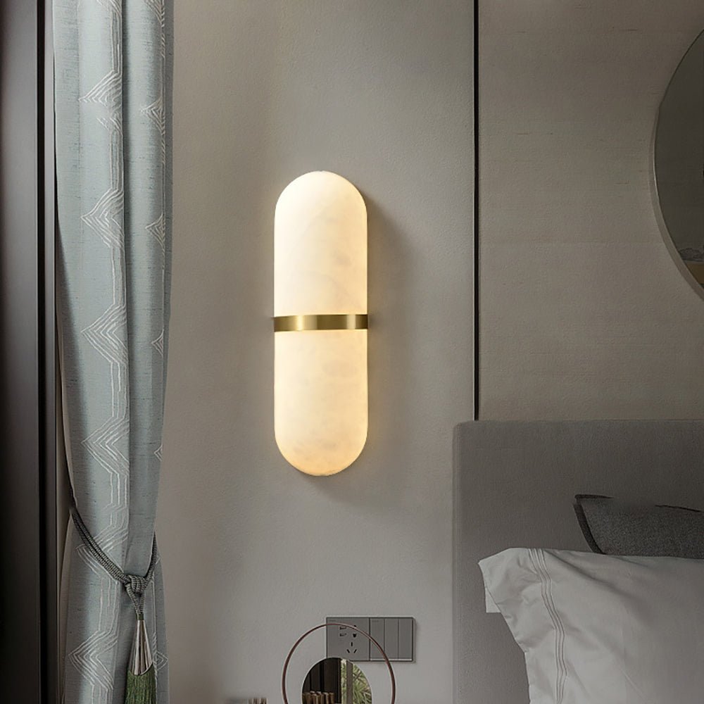 Illuminated Capsule Alabaster Sconce mounted beside bedroom headboard wall