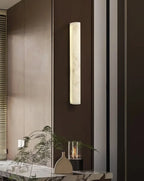Modern Vertical Cylindrical Alabaster Wall Sconce on Dark Wood Wall