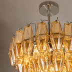 Angled View of Illuminated Modern Cascading Amber Faceted Art Glass Chandelier Studio Shot