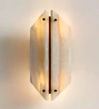 Geometric Travertine Sconce Glowing Warm Light on White Background