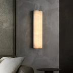 Double Cylinder Alabaster Wall Sconce Over Bedside Table