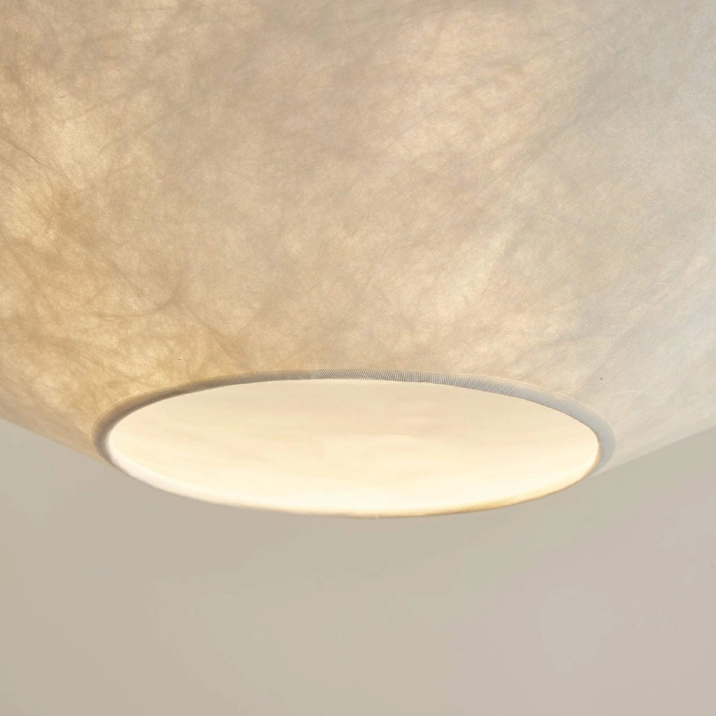 Close Up View of Illuminated White Fabric Shade and Metal Rim