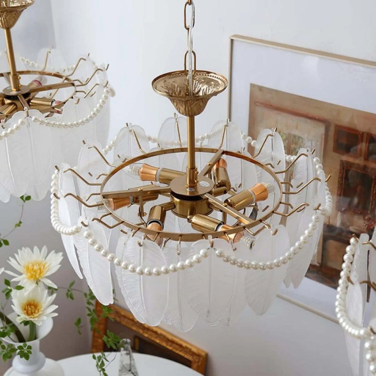Detailed view of the chandelier's translucent ivory glass shades with feather-like textures