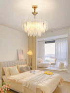 Gold Feather Glass Chandelier above a bed in a warm contemporary bedroom
