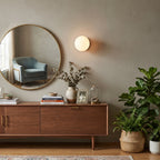 Globe Glass Sconce Light Over Credenza Beside Wall Mirror
