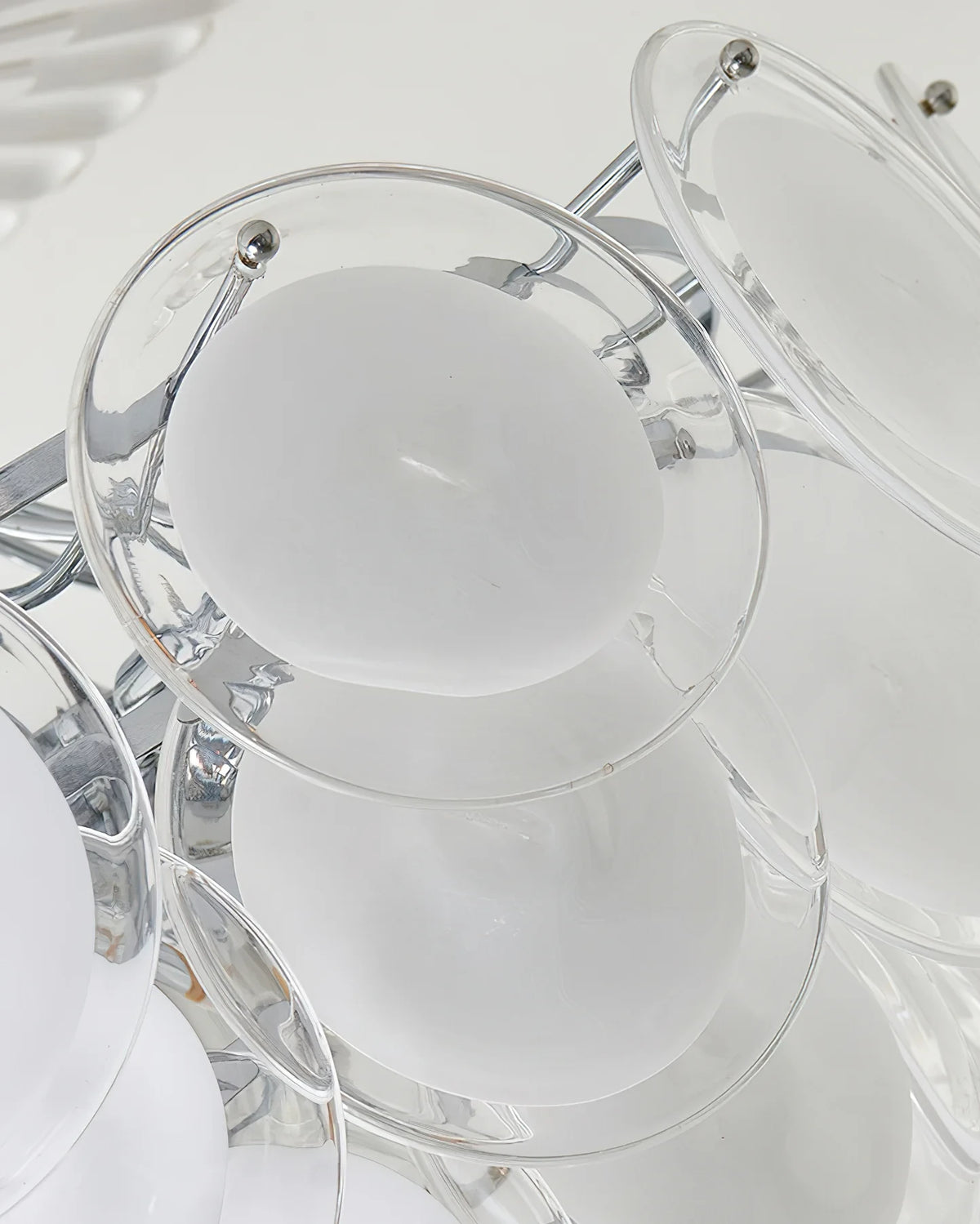 Close Up View of White Disc Glass Shades and Silver Metal Connector Structure