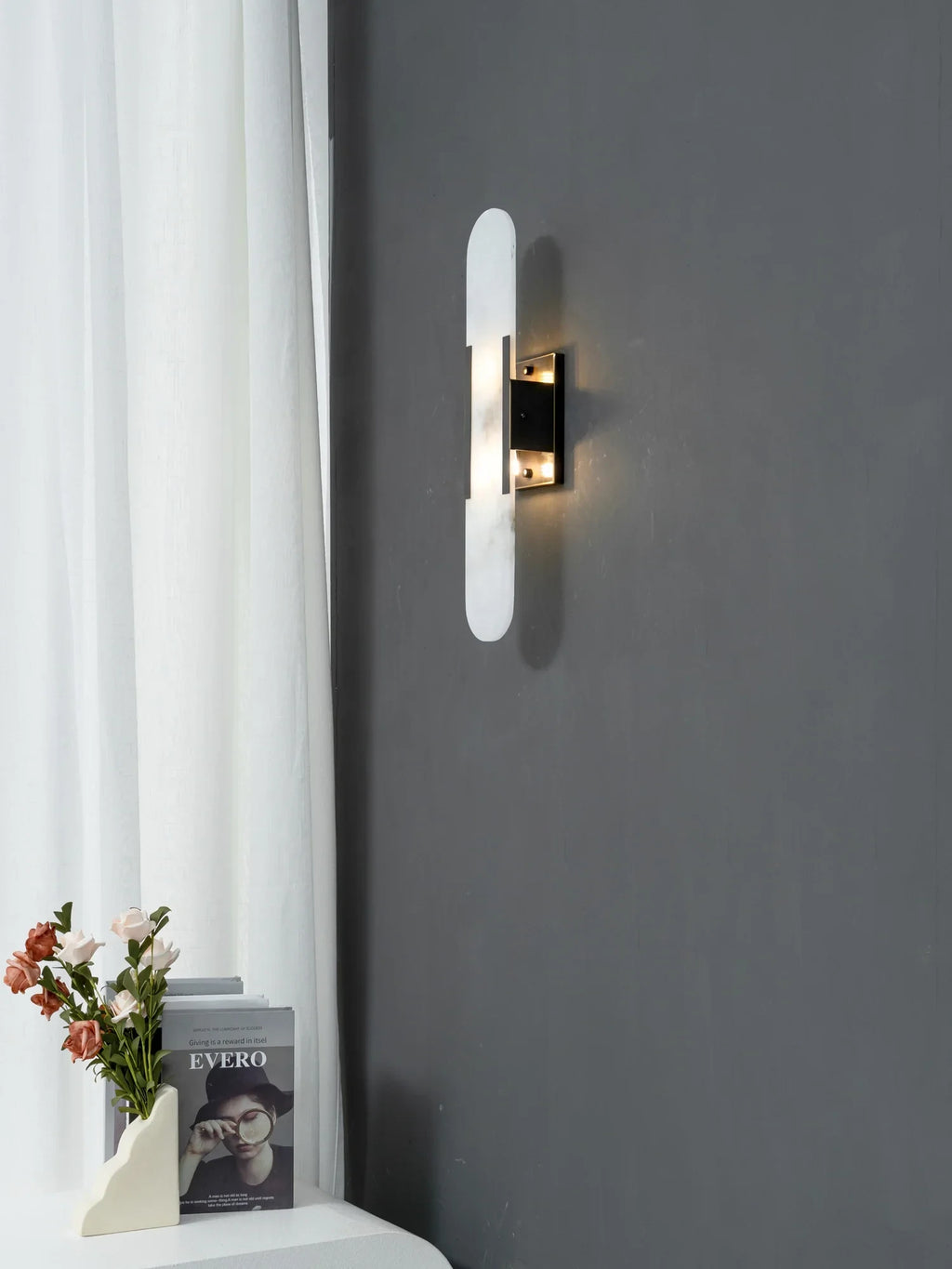 Modern Capsule Alabaster Wall Sconce with Black Hardware on Dark Wall