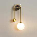 Modern Brass Curved Tube and Glass Globe Wall Sconce Off State Studio Display