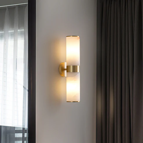 Brass Linear Tandem wall sconce with natural alabaster shade beside window curtains in modern hallway
