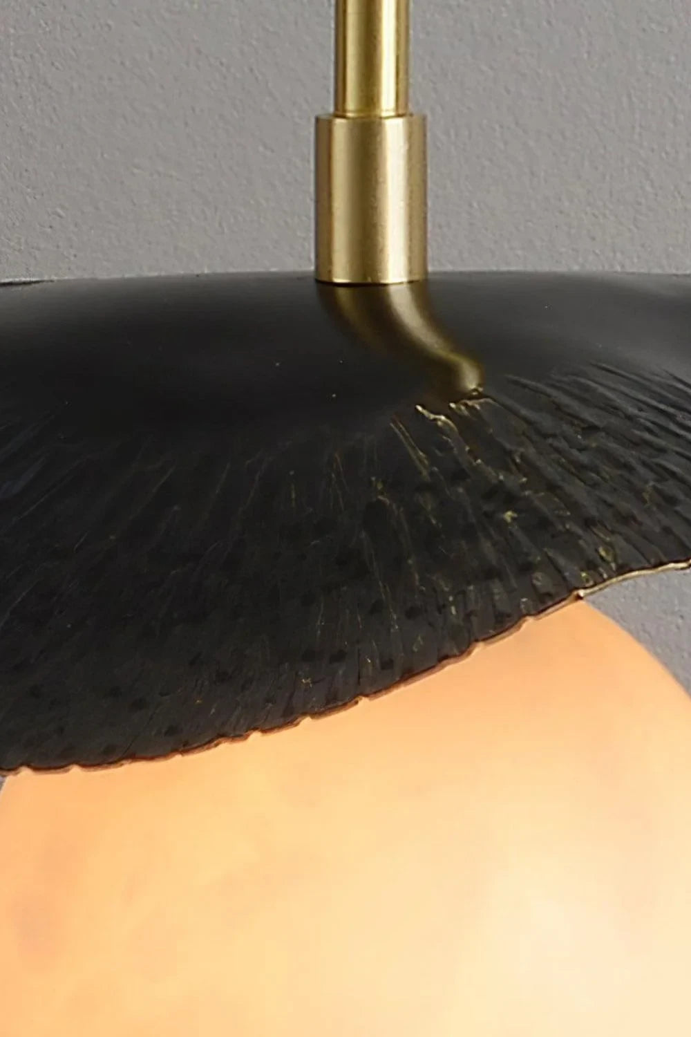 Close Up View of Black Disc Shade and Brass Rod Connection