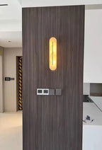 Capsule Alabaster LED Wall Light Mounted on Wood Panel Wall