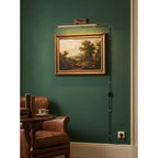 Traditional Brass Picture Light Against Green Accent Wall
