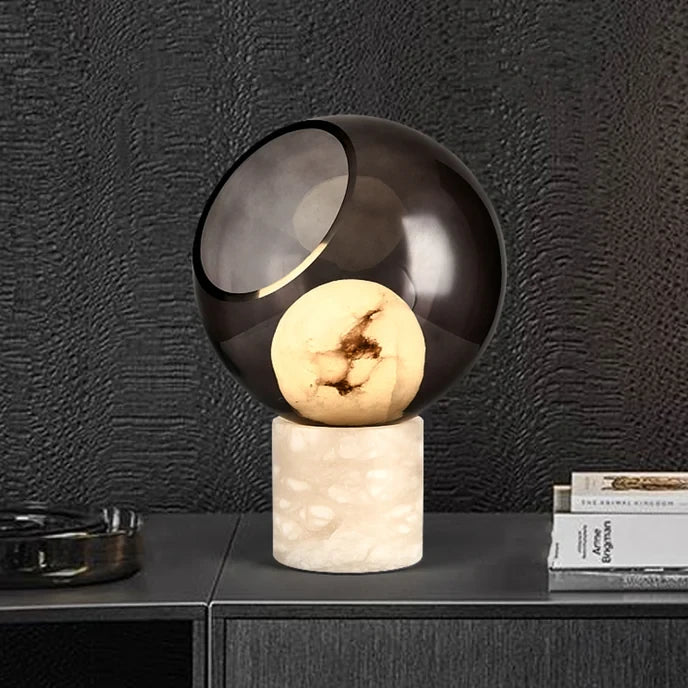 Illuminated Modern Smoked Grey Glass Table Lamp with Marble Base on Dark Background