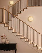 Modern Oval Alabaster Wall Sconce Along Staircase Hallway