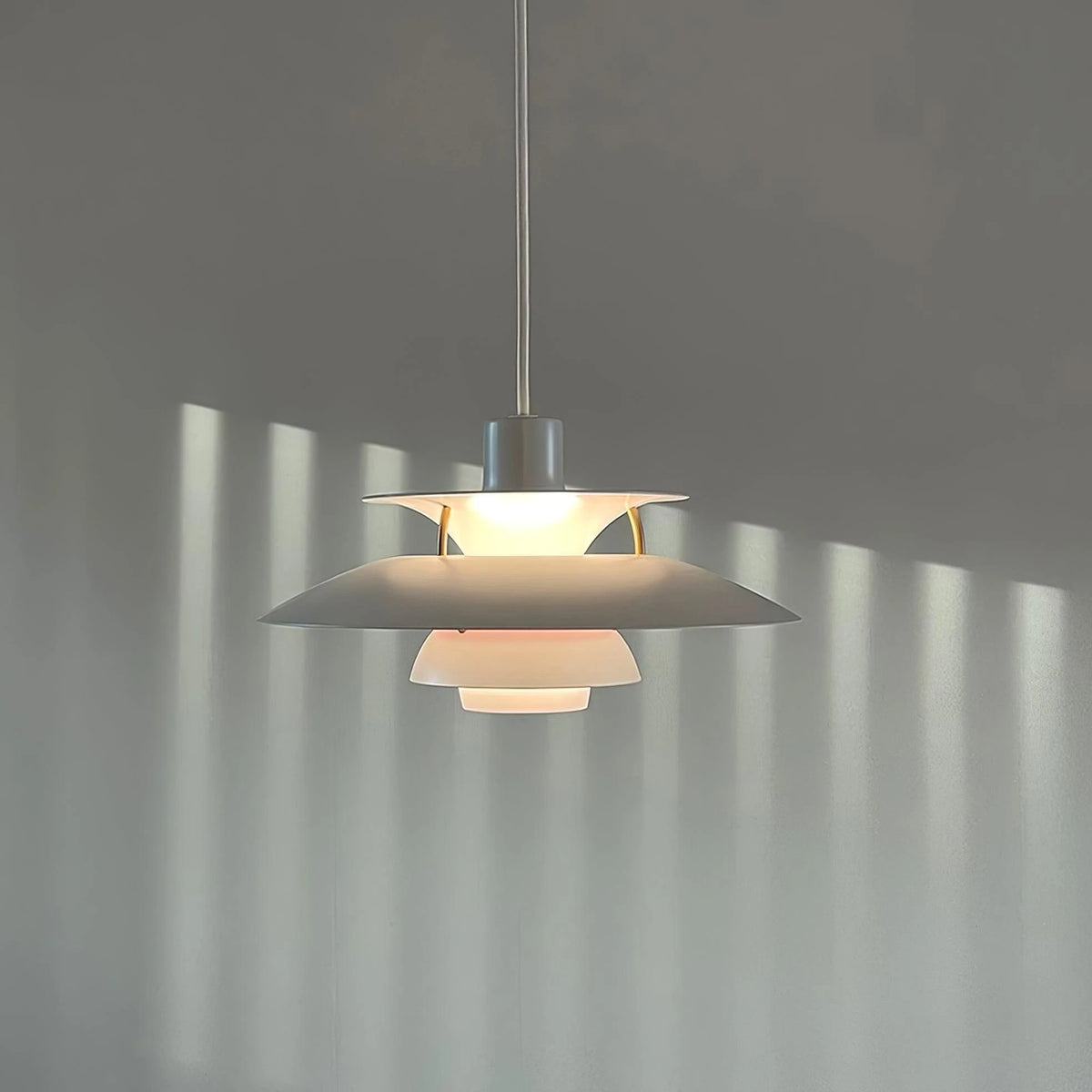 Illuminated Modern Nordic Pendant Light Casting Light Patterns on Wall