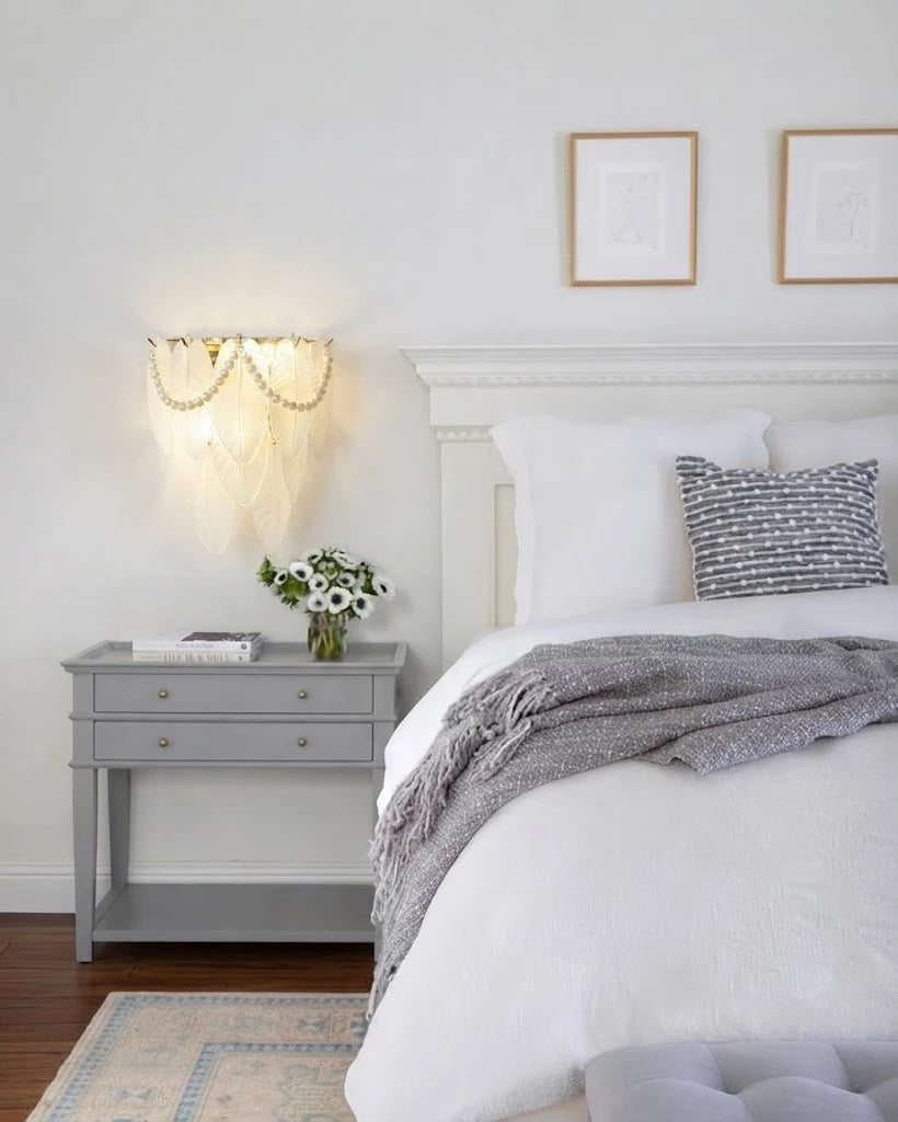 Modern Brass Frosted White Feather Wall Sconce with Pearl Strand in Bedroom Setting