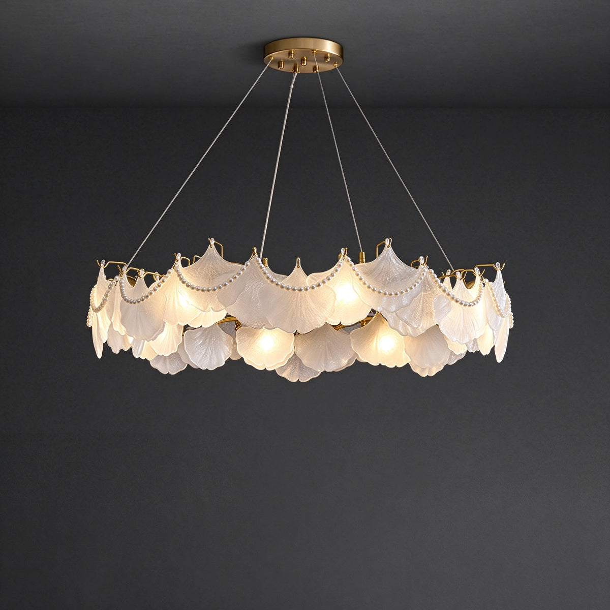 Upward View of Illuminated Modern Feather Wave Art Glass Chandelier with Pearls on Black Background