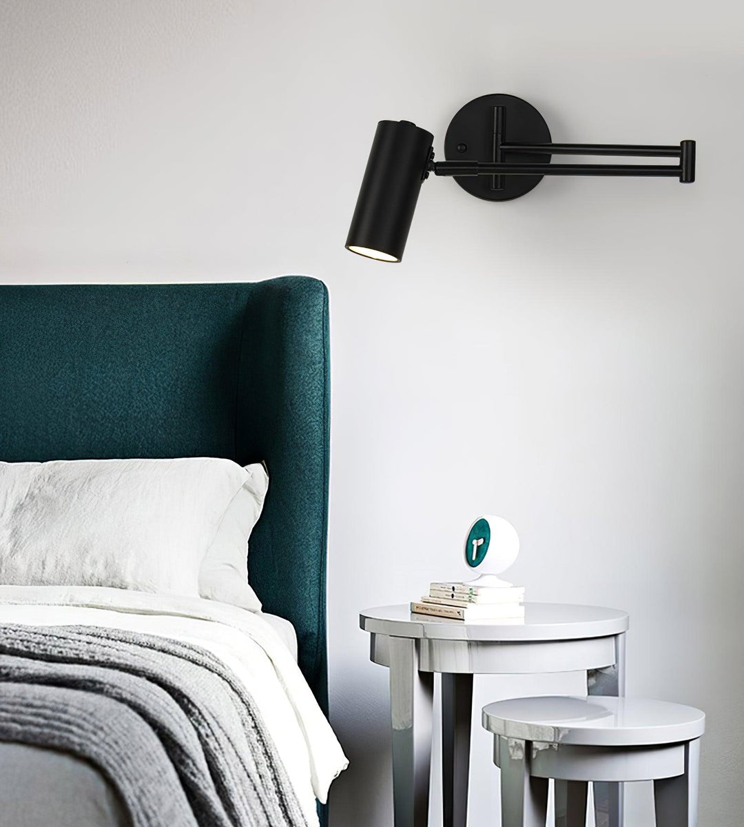 Black Swing Arm Wall Sconce Over Bedside Table