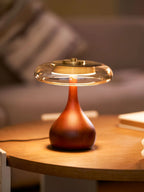 Illuminated Modern Amber Glass Wood Table Lamp on Wooden Table