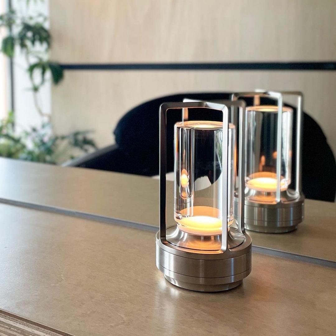 Pair silver Turn Plus cordless table lamps illuminated on light dining table