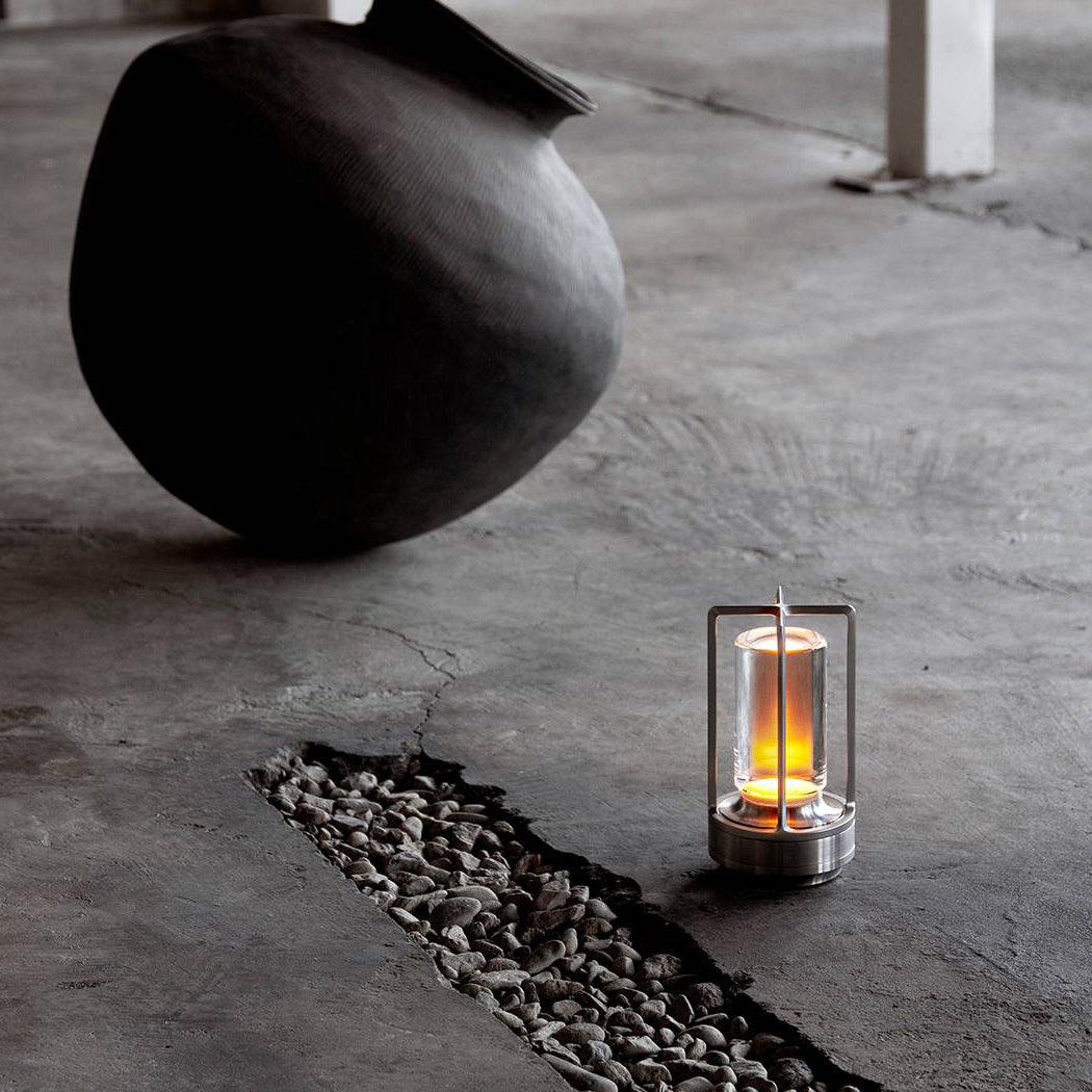 Brass cordless table lamp on dark wood table warm interior scene