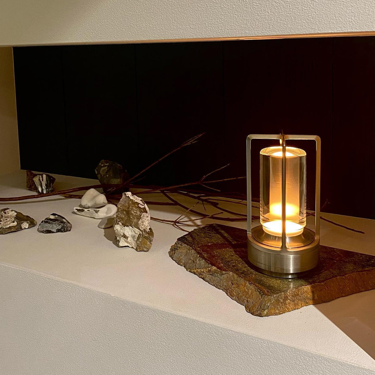 Turn Plus clear cylinder table lamp on dark table warm product shot