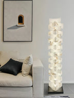 Modern Stacked Alabaster Floor Lamp Over Cozy Sofa Corner