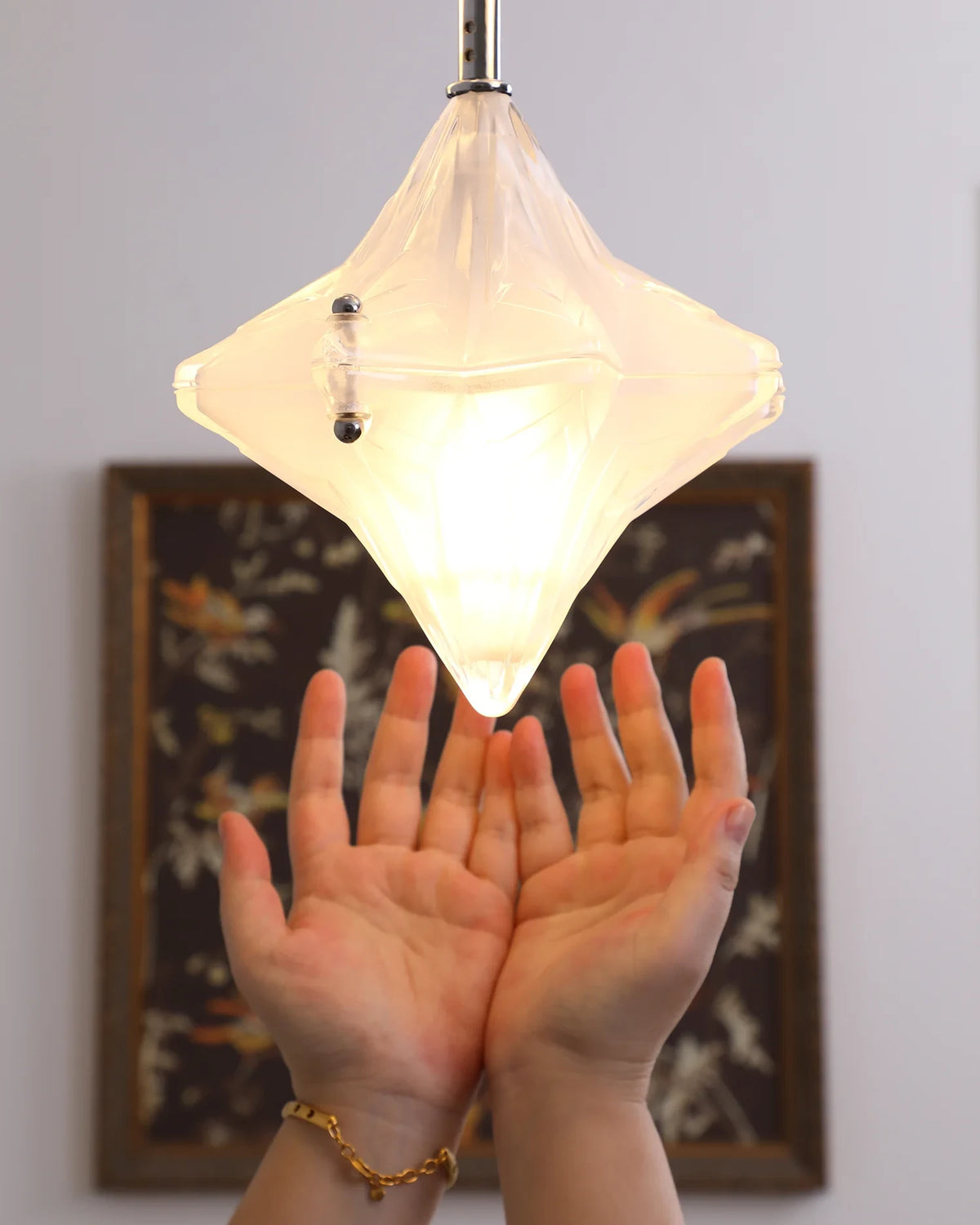 Close Up View of Illuminated Diamond Glass Shade Held in Hands