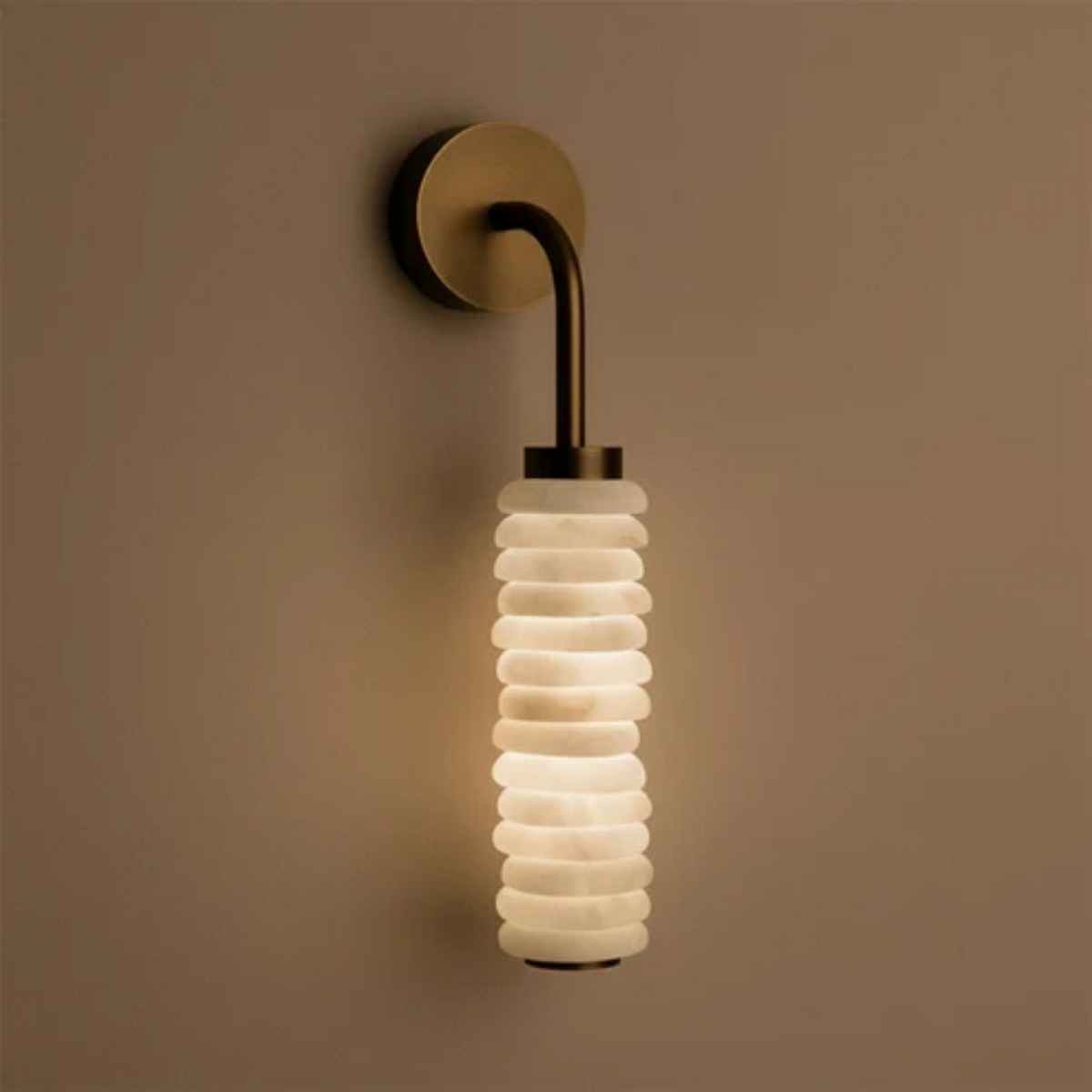 Illuminated Totem Alabaster Wall Lamp on warm beige plaster wall closeup view