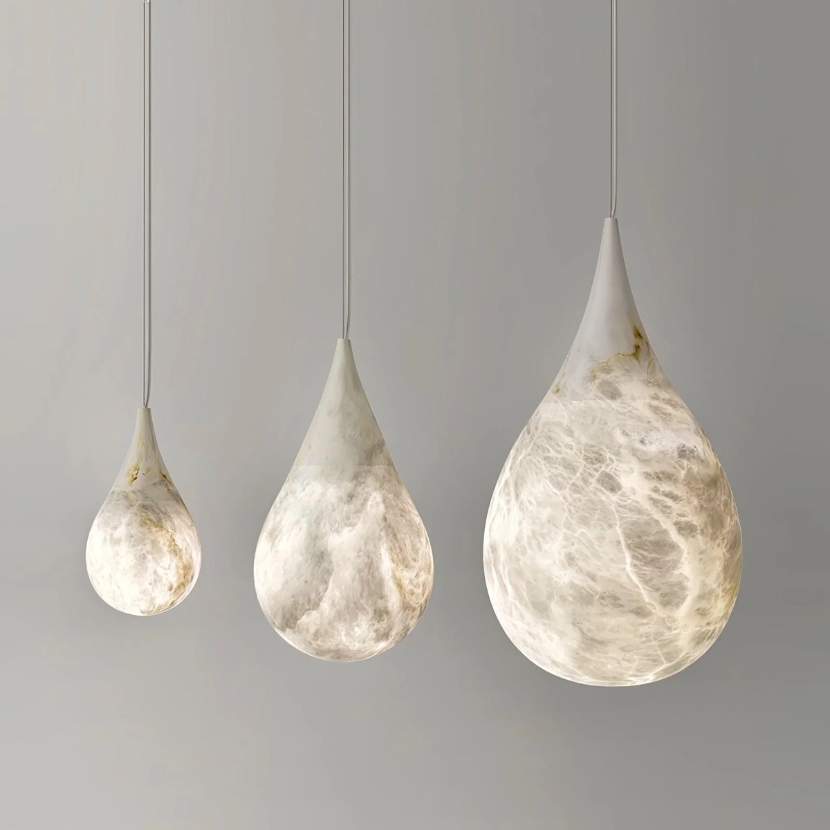Three varying sizes Tova Teardrop Alabaster Pendant Lamps arranged in a row